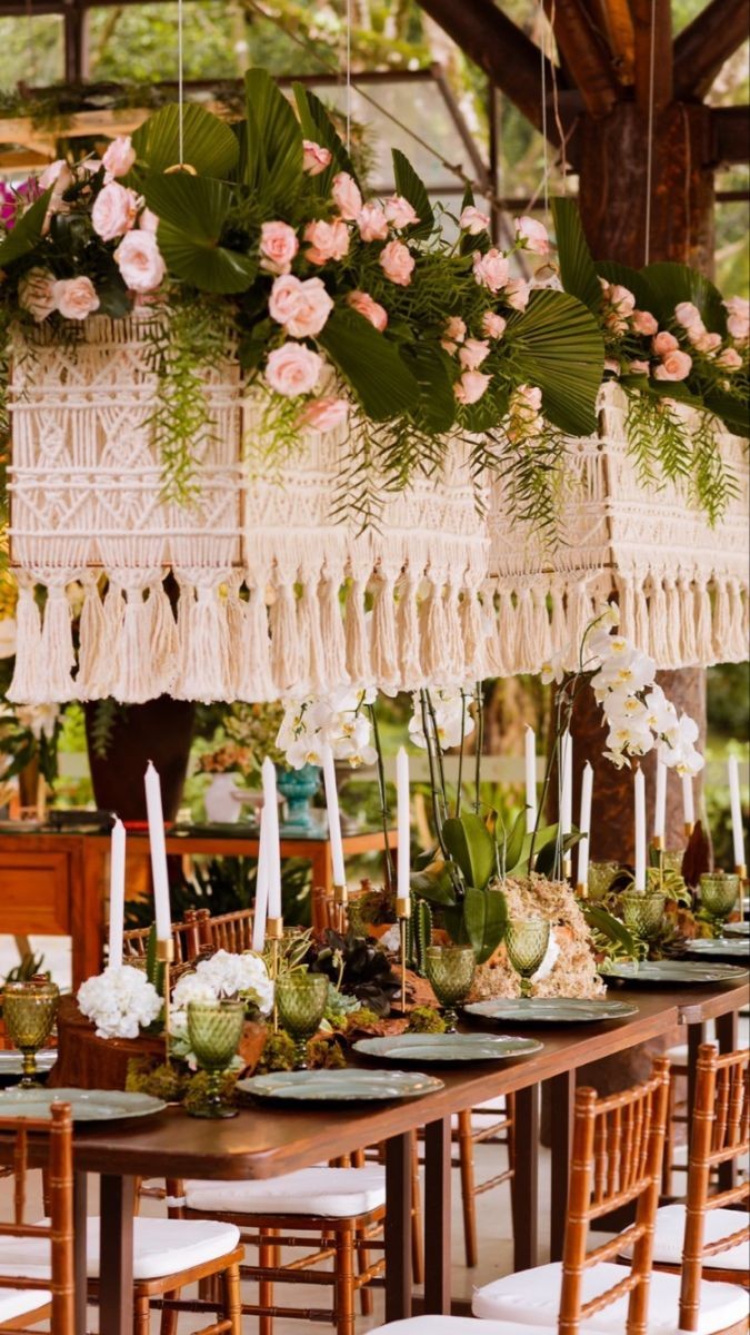 Mesa de casamento decorada com cúpulas de macramê franjadas, flores e velas